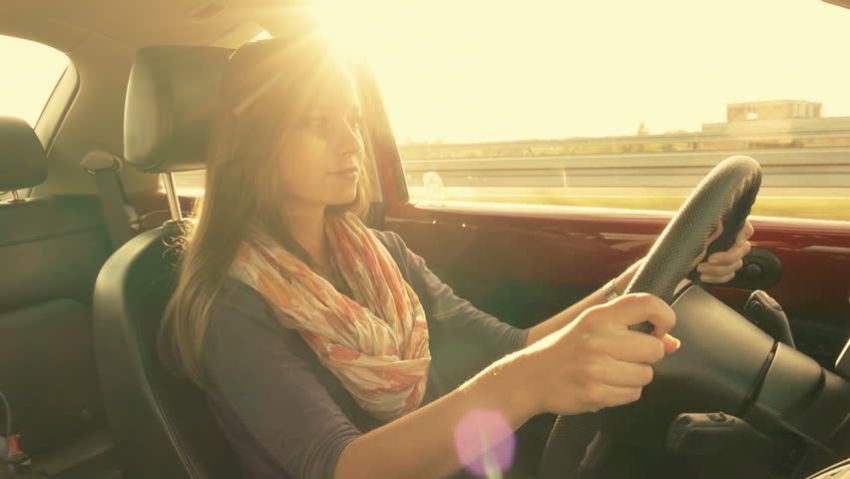 femme conduisant une voiture sous le soleil